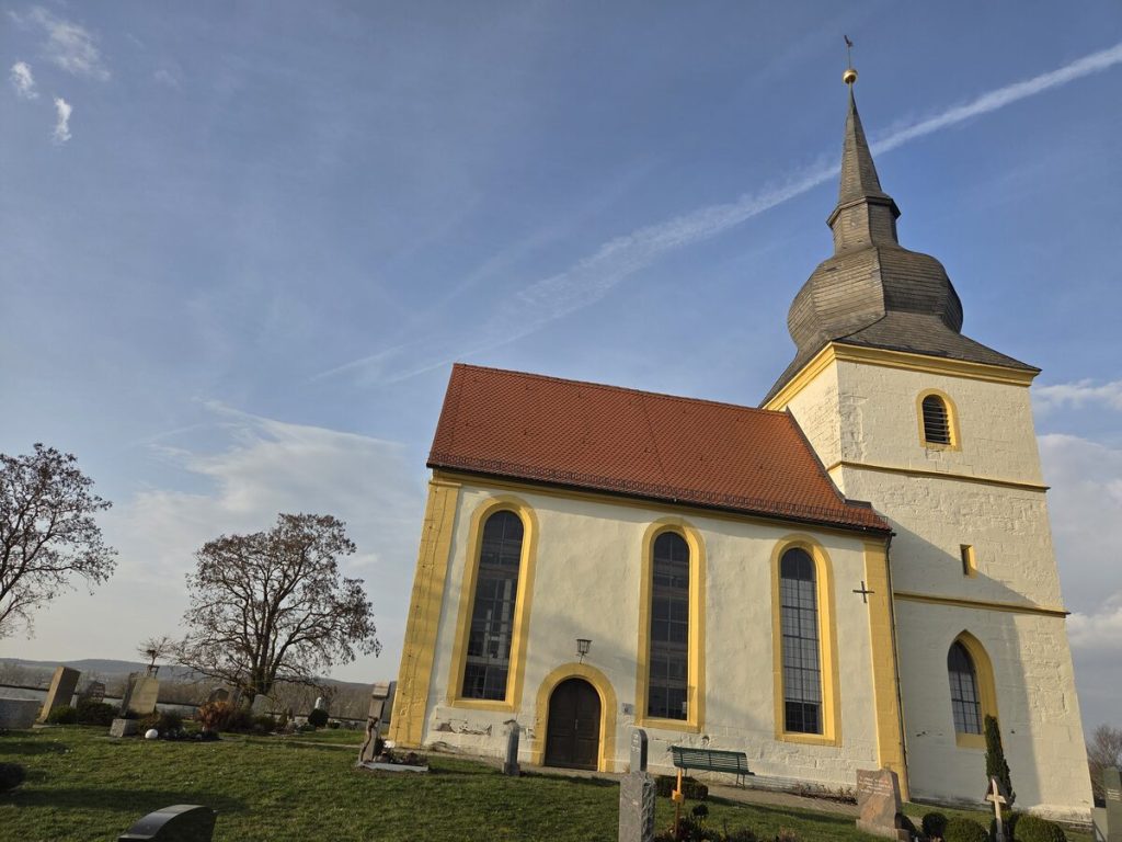 Die St. Michaelis Kirche am Friedhof mit ihrem markanten Zwiebelturm und rotem Ziegeldach